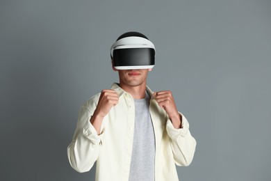 Photo of Man using virtual reality headset on gray background