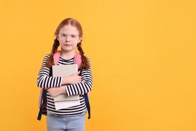 Little girl with book on yellow background. Space for text