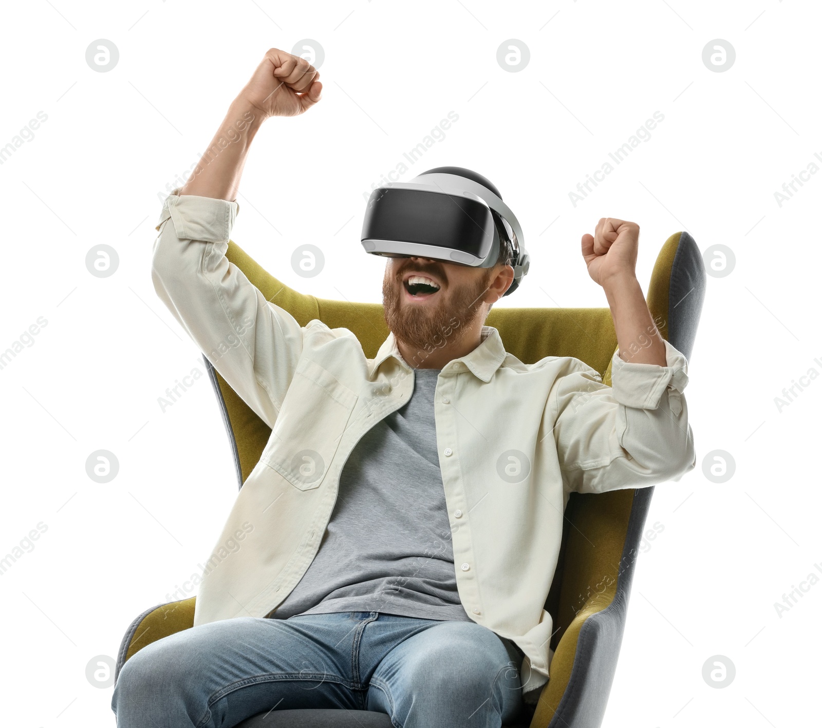 Photo of Smiling man using virtual reality headset while sitting in armchair on white background