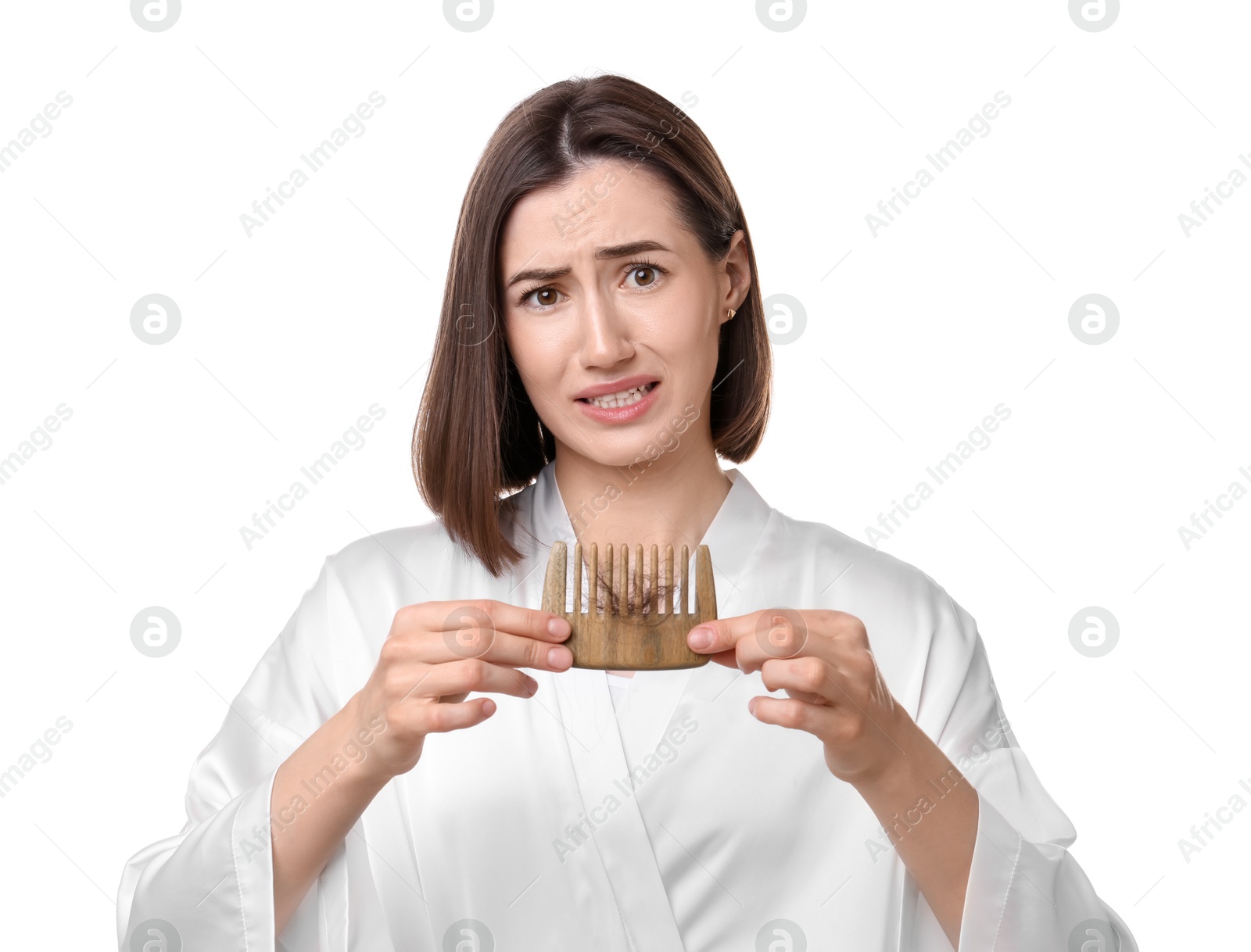 Photo of Emotional woman holding comb with lost hair on white background. Alopecia problem