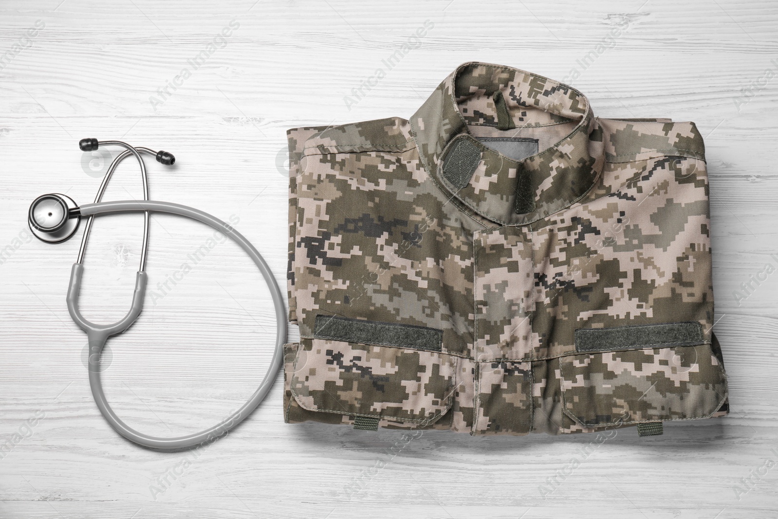 Photo of Stethoscope and military uniform on white wooden background, flat lay