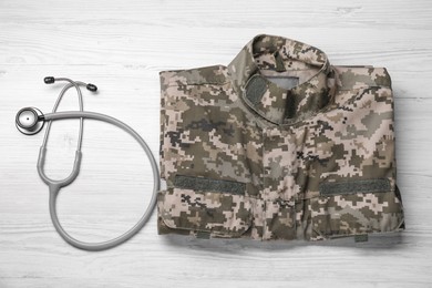 Stethoscope and military uniform on white wooden background, flat lay