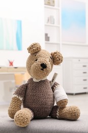 Photo of Toy cute bear with bandage and thermometer indoors