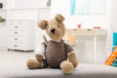 Photo of Toy cute bear with bandage and thermometer indoors