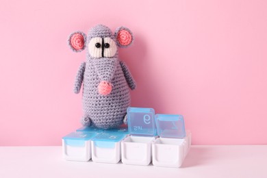 Photo of Toy rat and containers with pills on color background