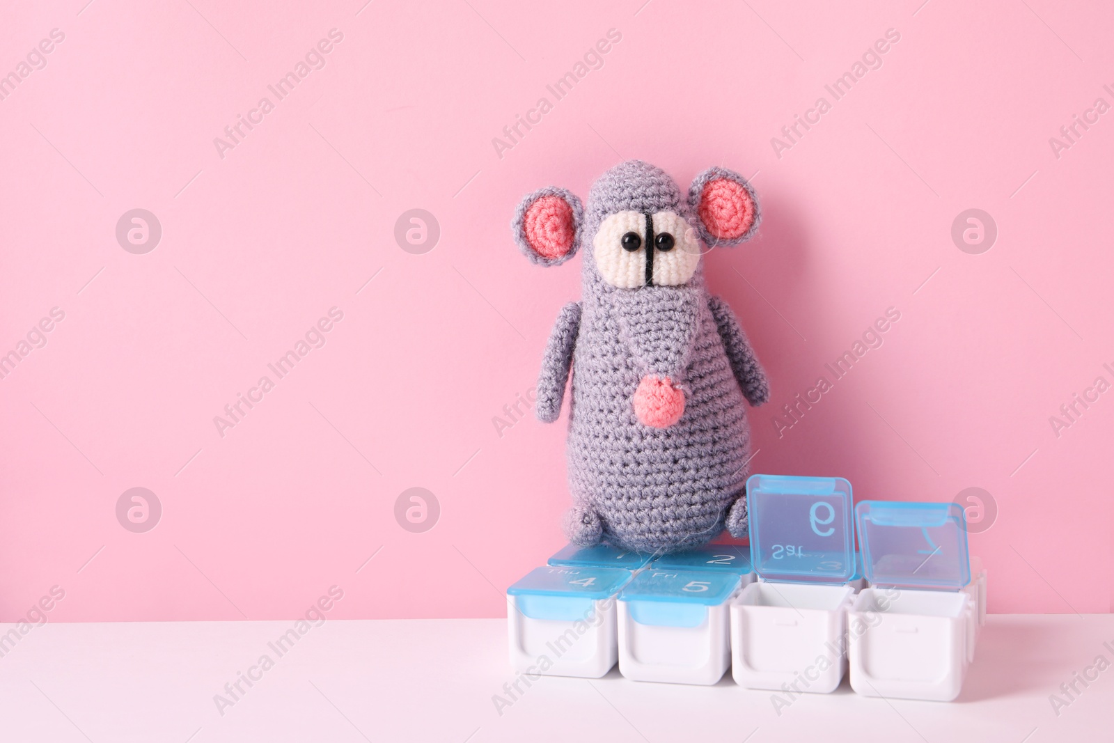 Photo of Toy rat and containers with pills on color background, space for text