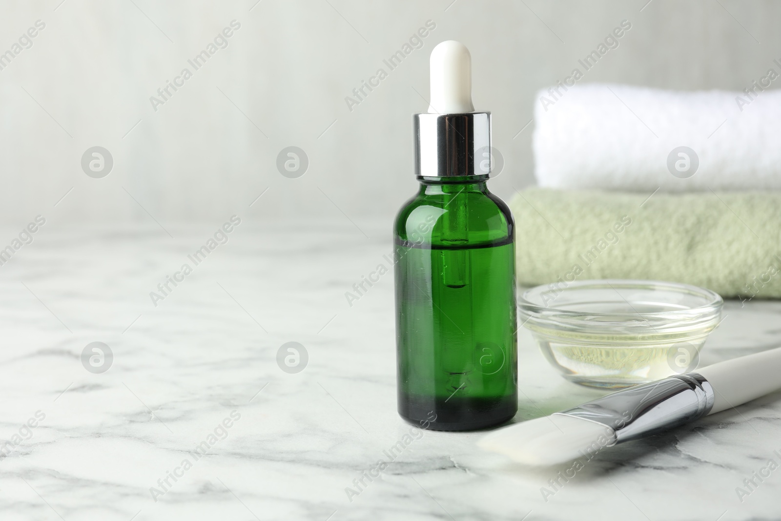 Photo of Bottle of chemical peel, bowl with liquid and brush on white marble table, space for text. Peeling procedure