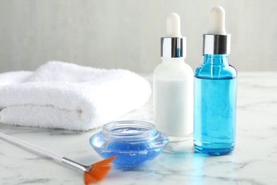 Photo of Bottles of chemical peel, bowl with liquid and brush on white marble table. Peeling procedure