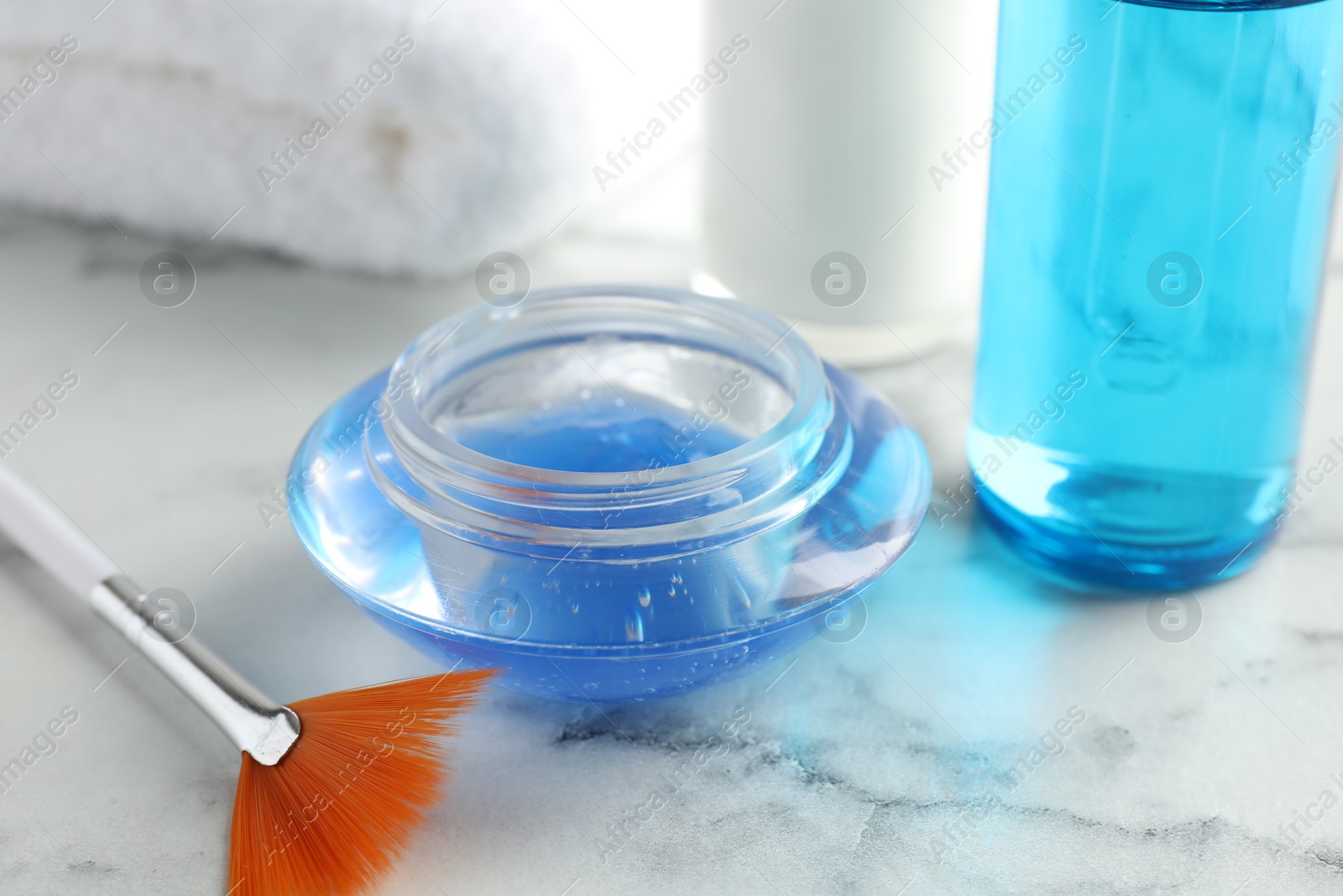 Photo of Chemical peel in bowl and brush on white marble table, closeup. Peeling procedure