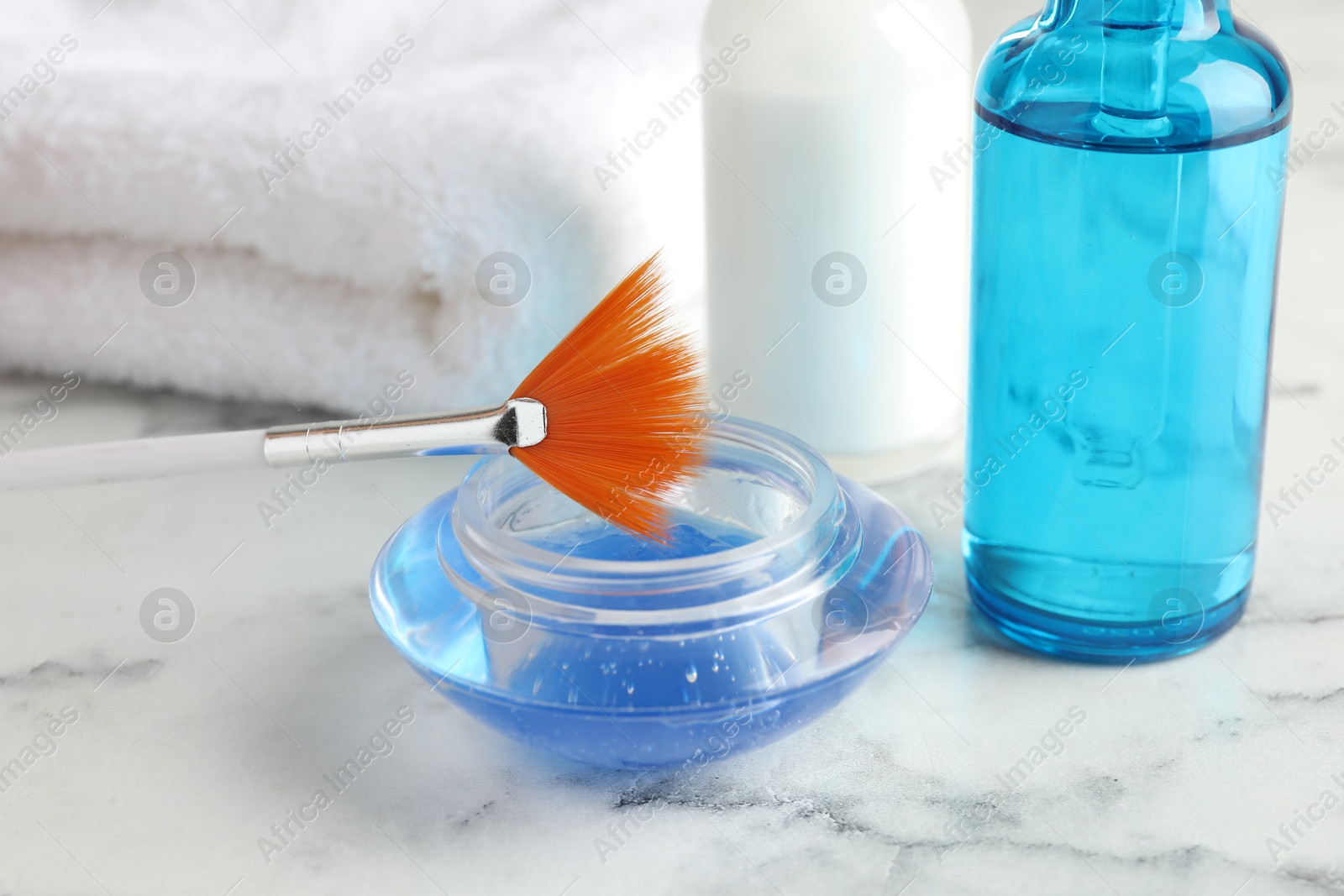 Photo of Chemical peel in bowl and brush on white marble table, closeup. Peeling procedure