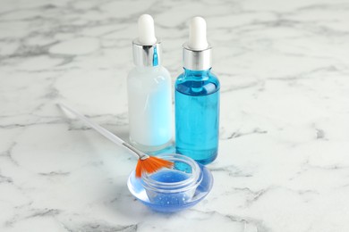 Photo of Bottles of chemical peel, bowl with liquid and brush on white marble table. Peeling procedure