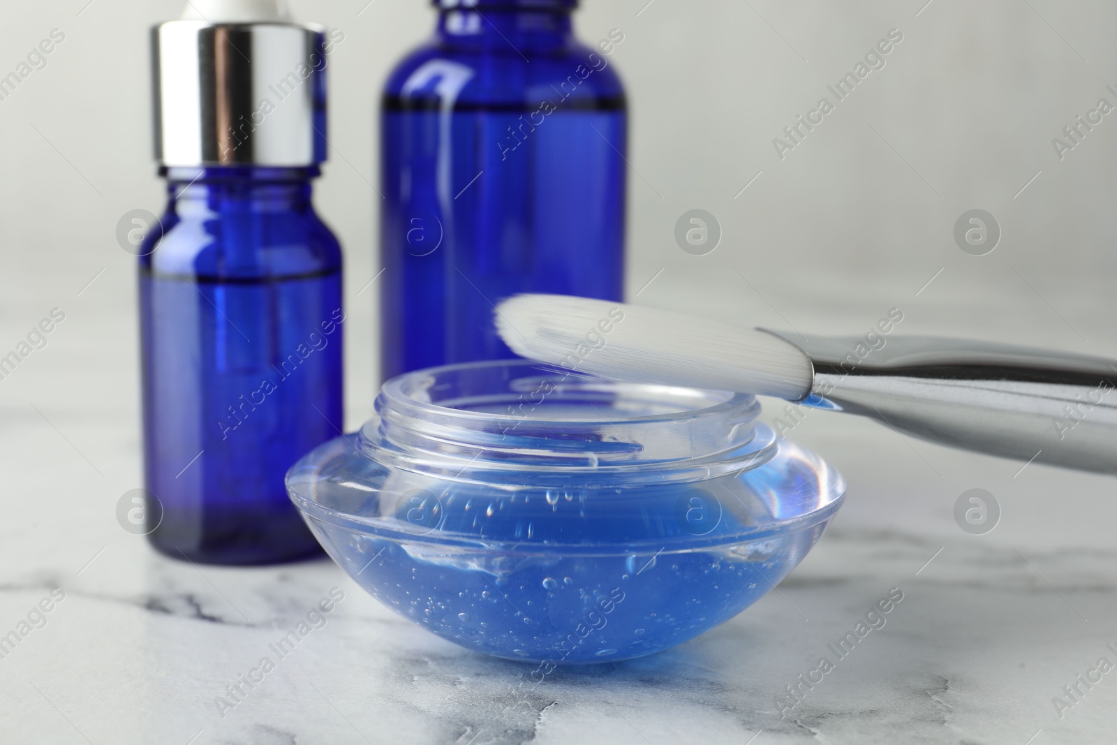 Photo of Chemical peel with brush on white marble table, closeup. Peeling procedure