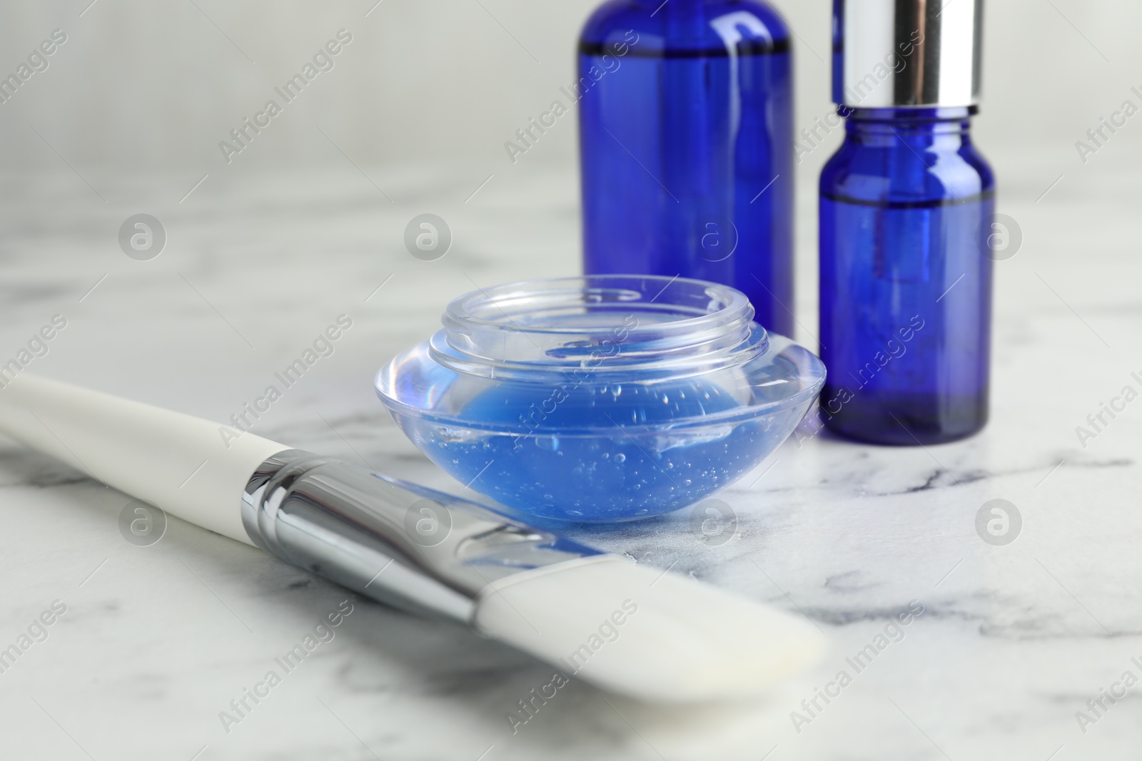 Photo of Chemical peel with brush on white marble table, closeup. Peeling procedure