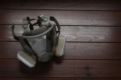 Photo of One respirator mask on wooden table, top view. Space for text