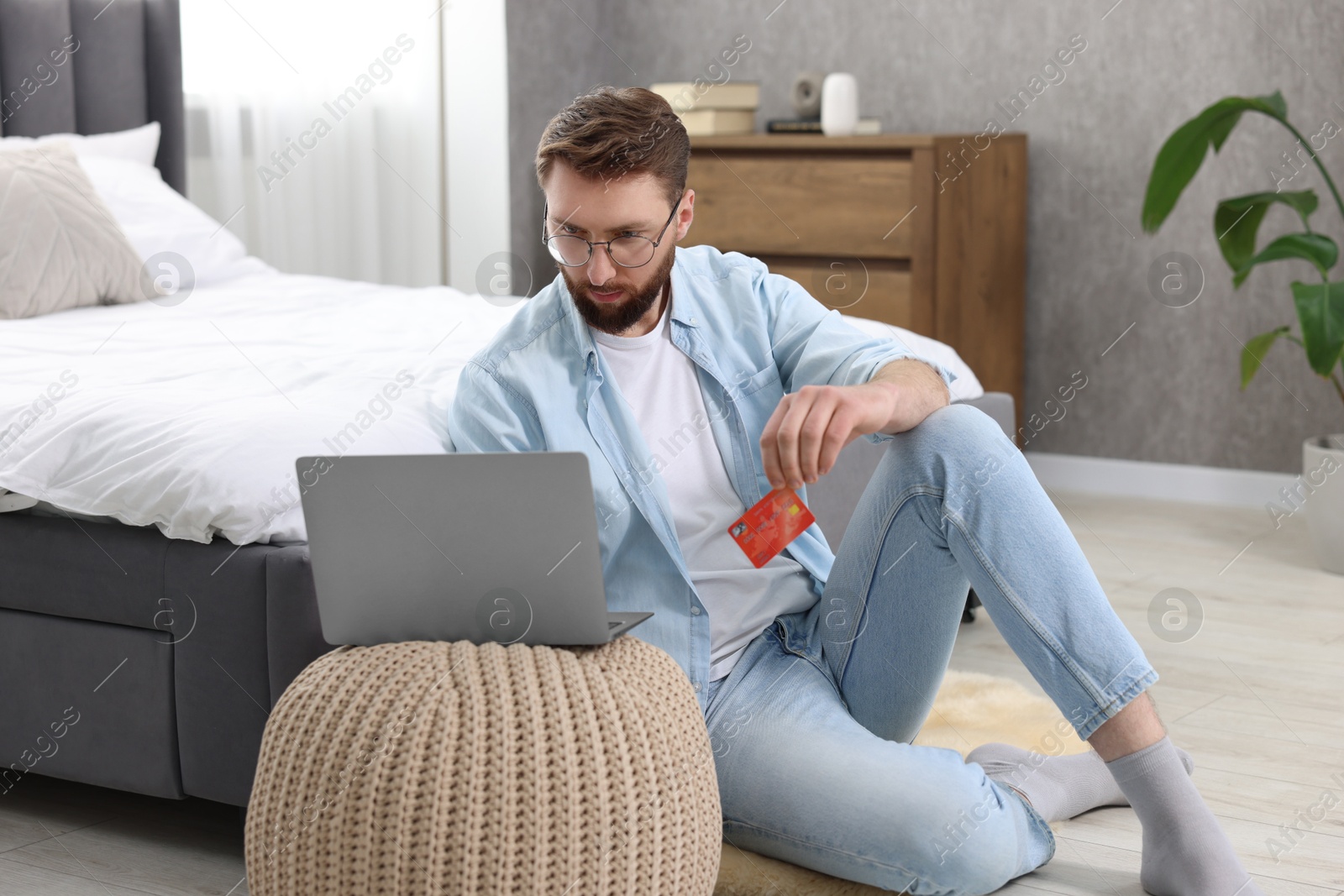 Photo of Online banking. Young man with credit card and laptop paying purchase at home