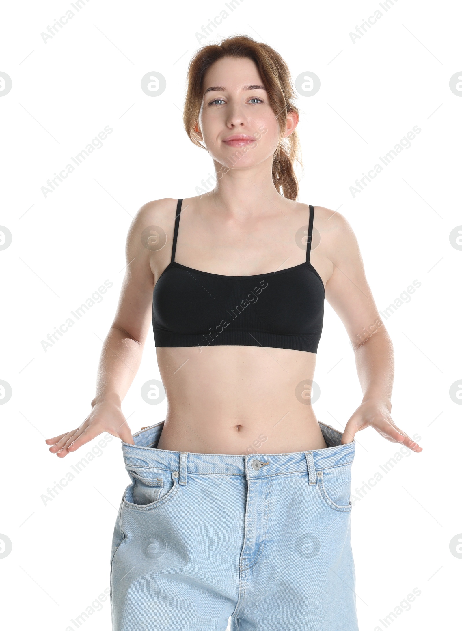 Photo of Woman in big jeans showing her slim body on white background