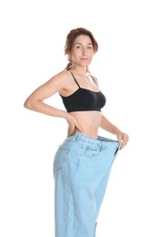 Photo of Woman in big jeans showing her slim body on white background