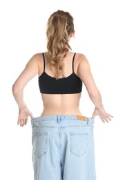 Photo of Woman in big jeans showing her slim body on white background, back view