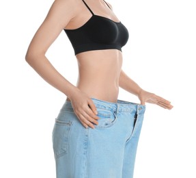 Woman in big jeans showing her slim body on white background, closeup