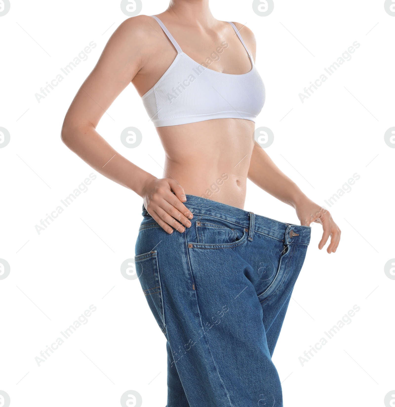 Photo of Woman in big jeans showing her slim body on white background, closeup