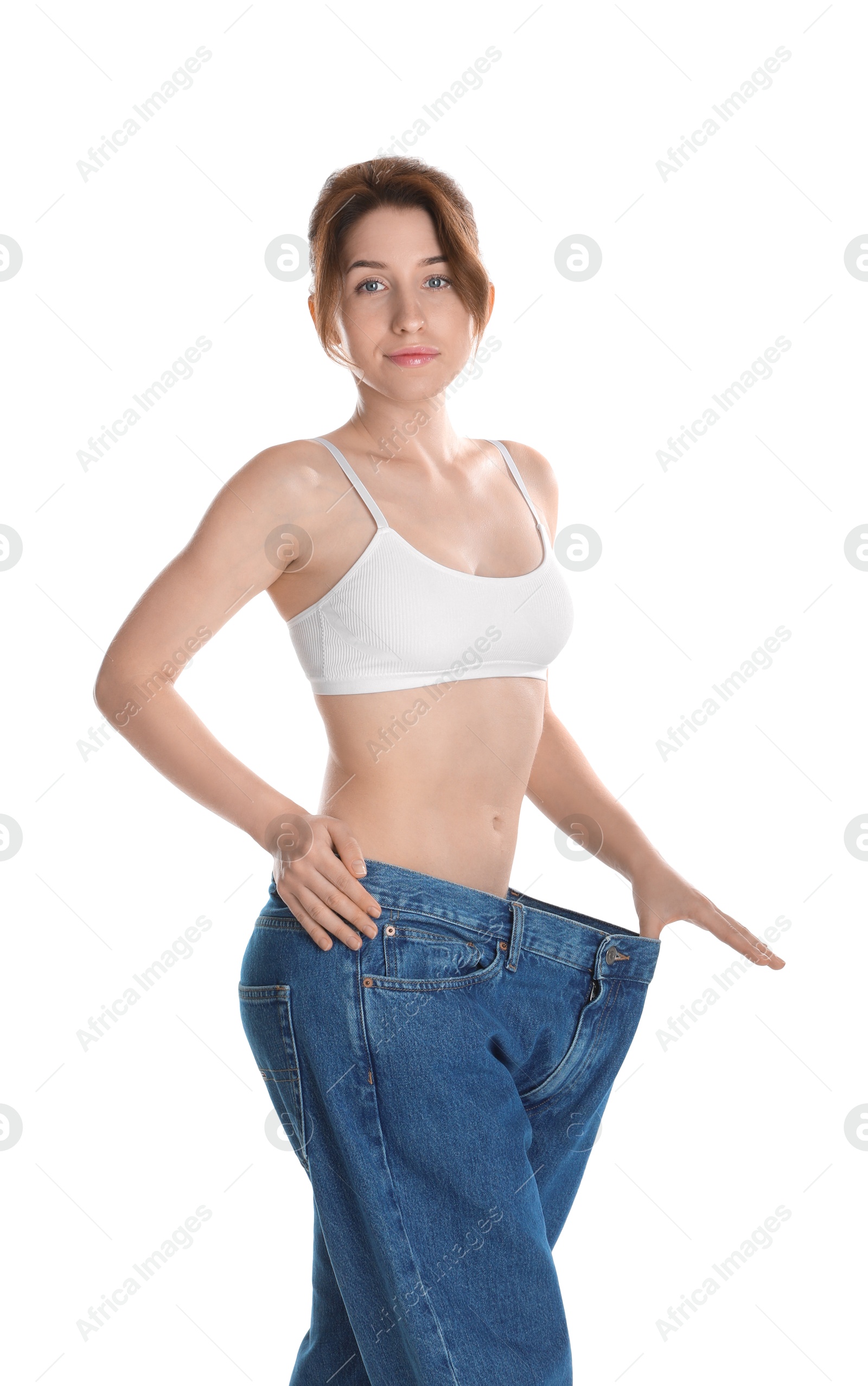 Photo of Woman in big jeans showing her slim body on white background