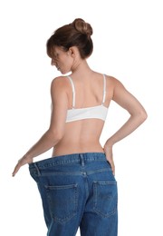 Woman in big jeans showing her slim body on white background