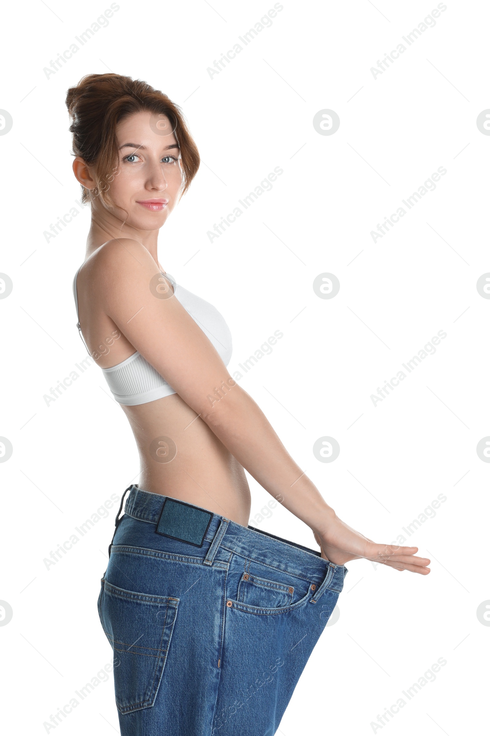 Photo of Woman in big jeans showing her slim body on white background