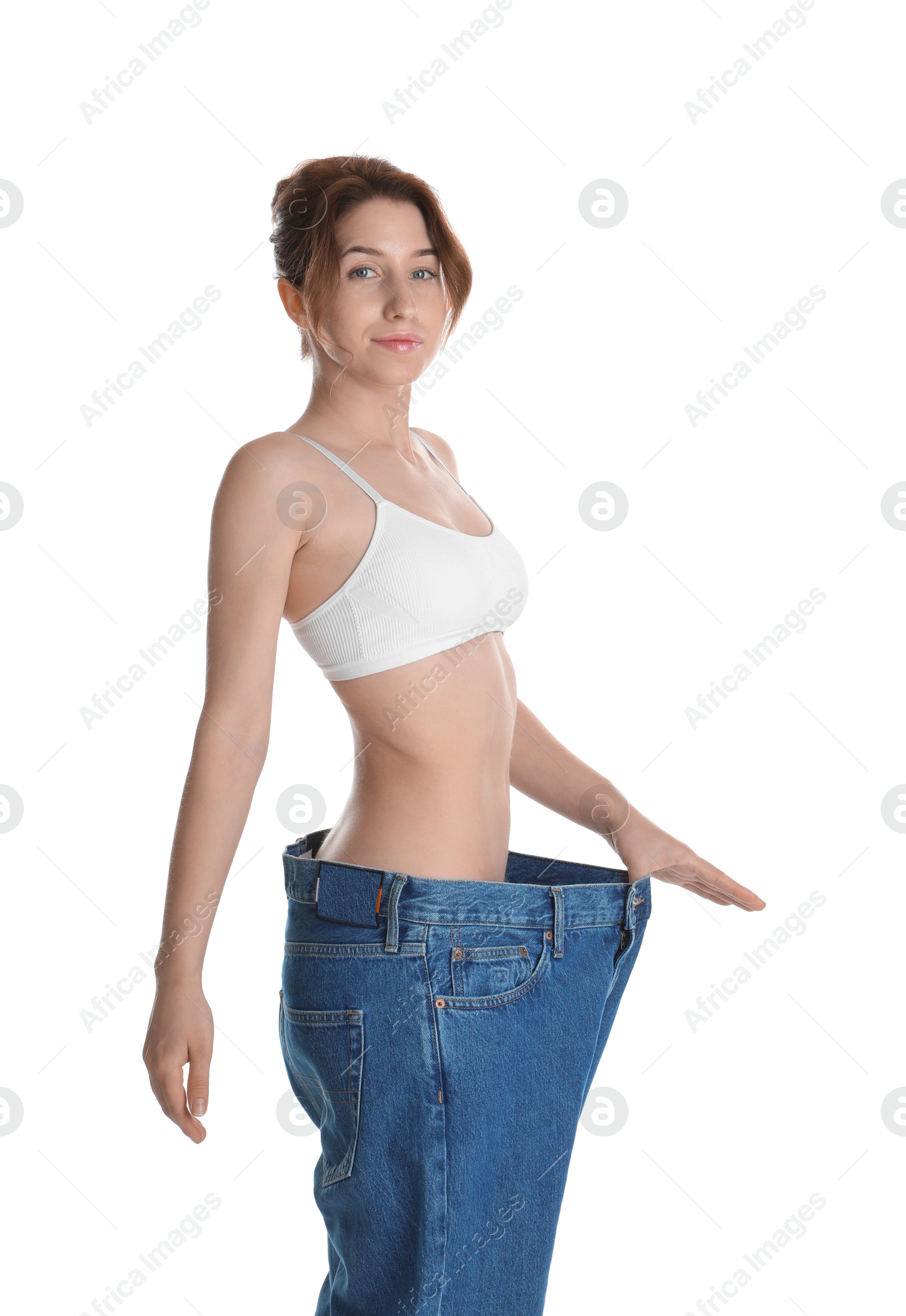 Photo of Woman in big jeans showing her slim body on white background