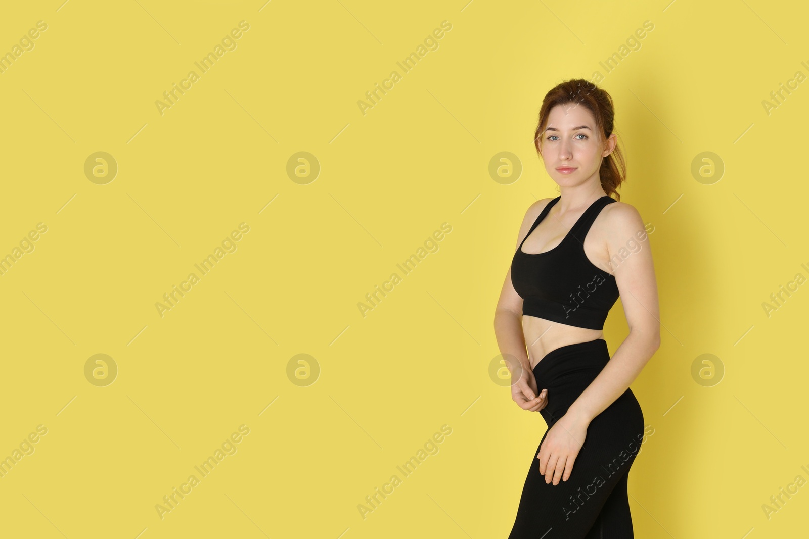 Photo of Woman with slim body posing on yellow background, space for text