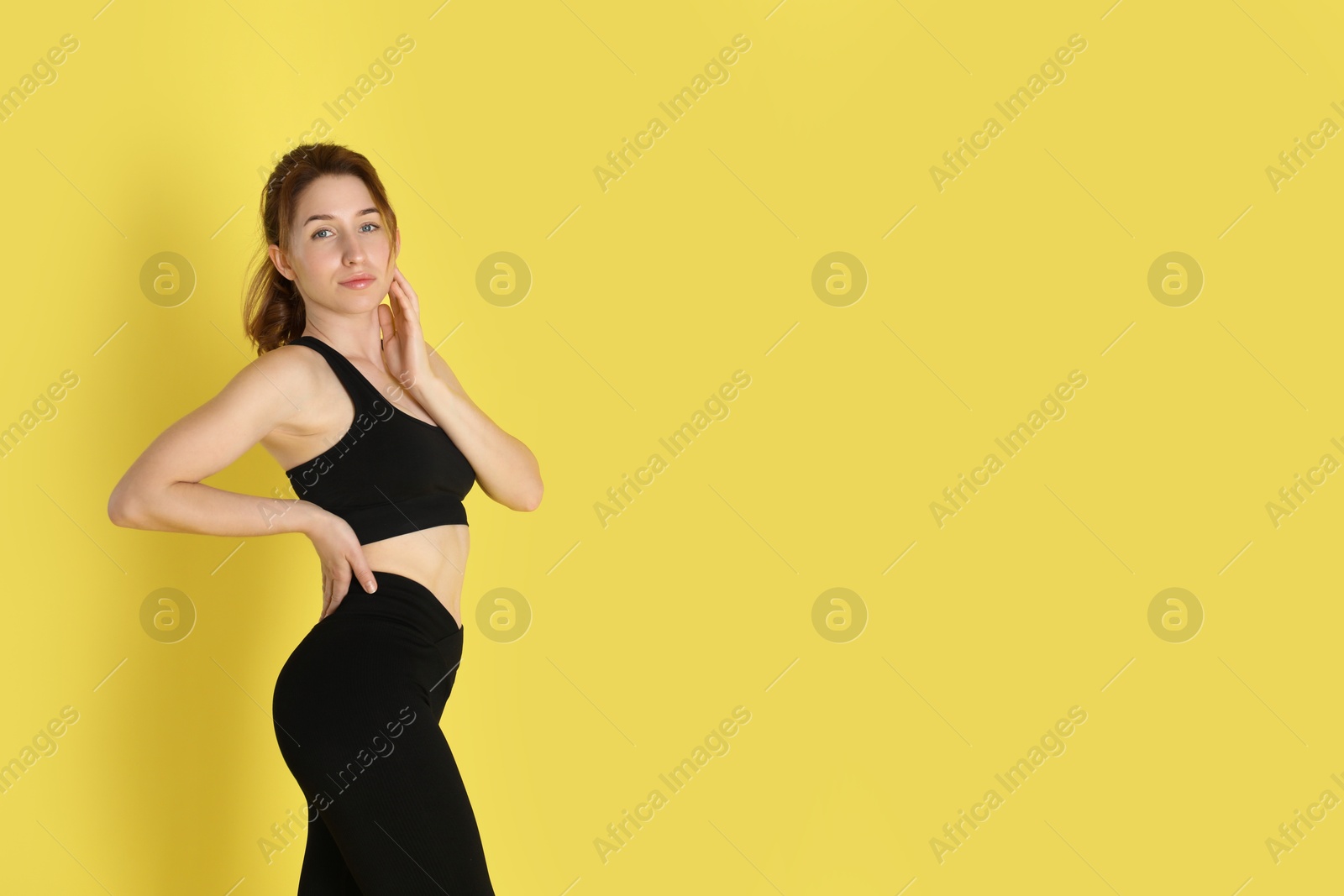 Photo of Woman with slim body posing on yellow background, space for text