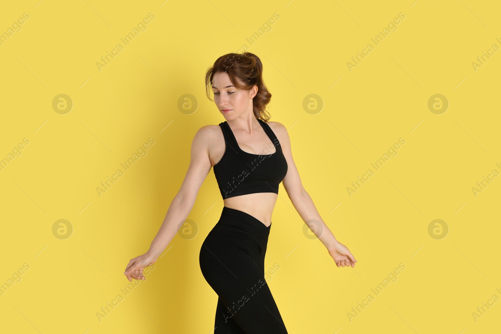 Photo of Woman with slim body posing on yellow background