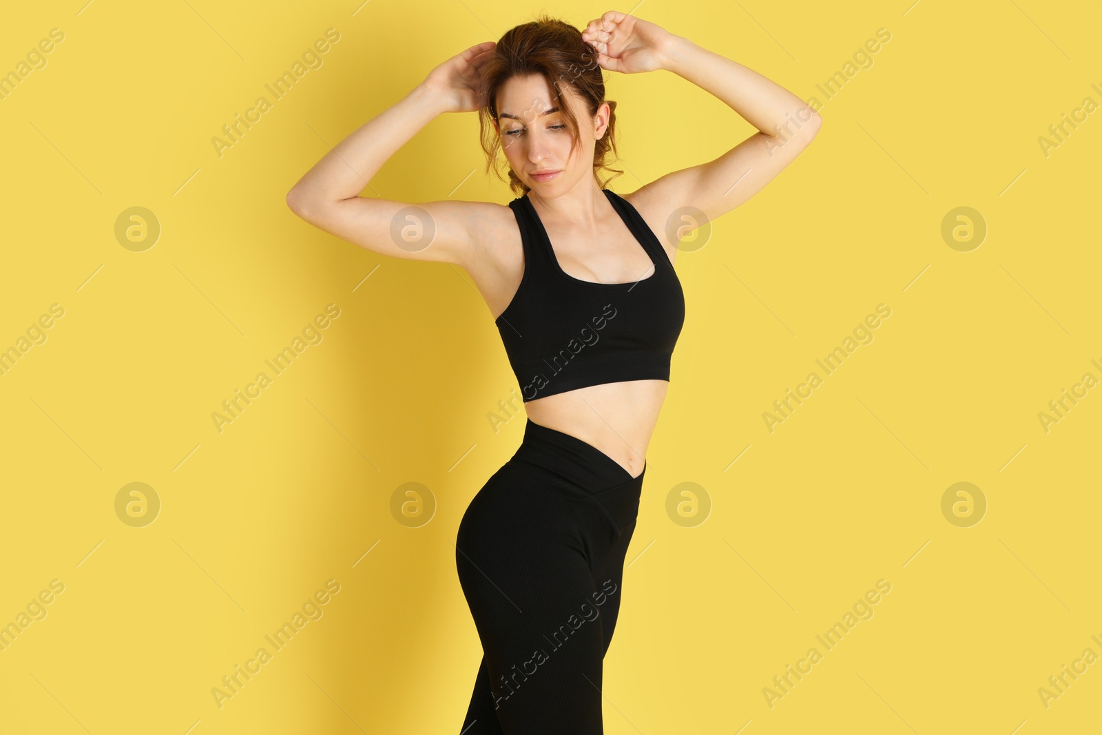 Photo of Woman with slim body posing on yellow background