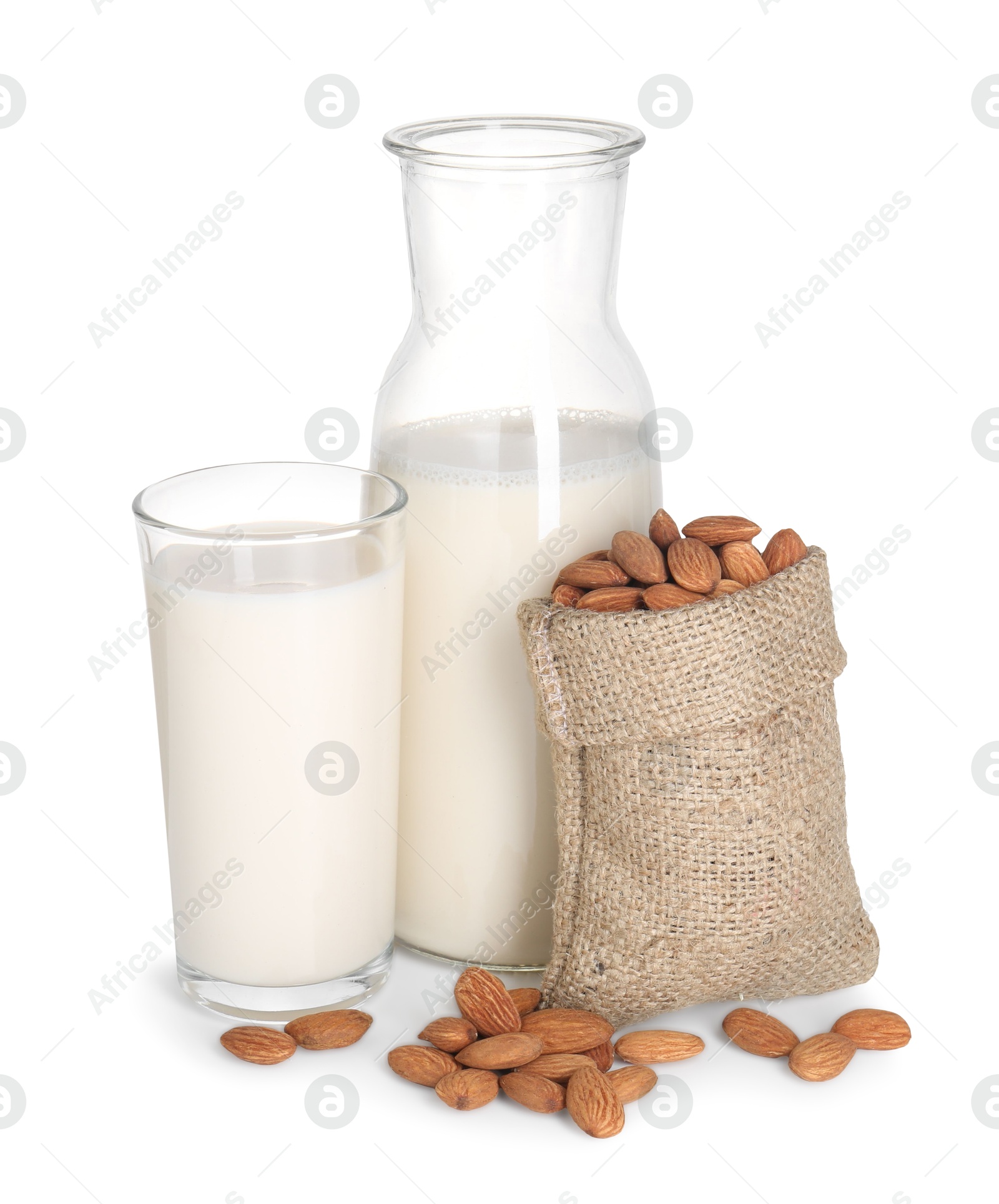 Photo of Glass of almond milk, jug and almonds isolated on white