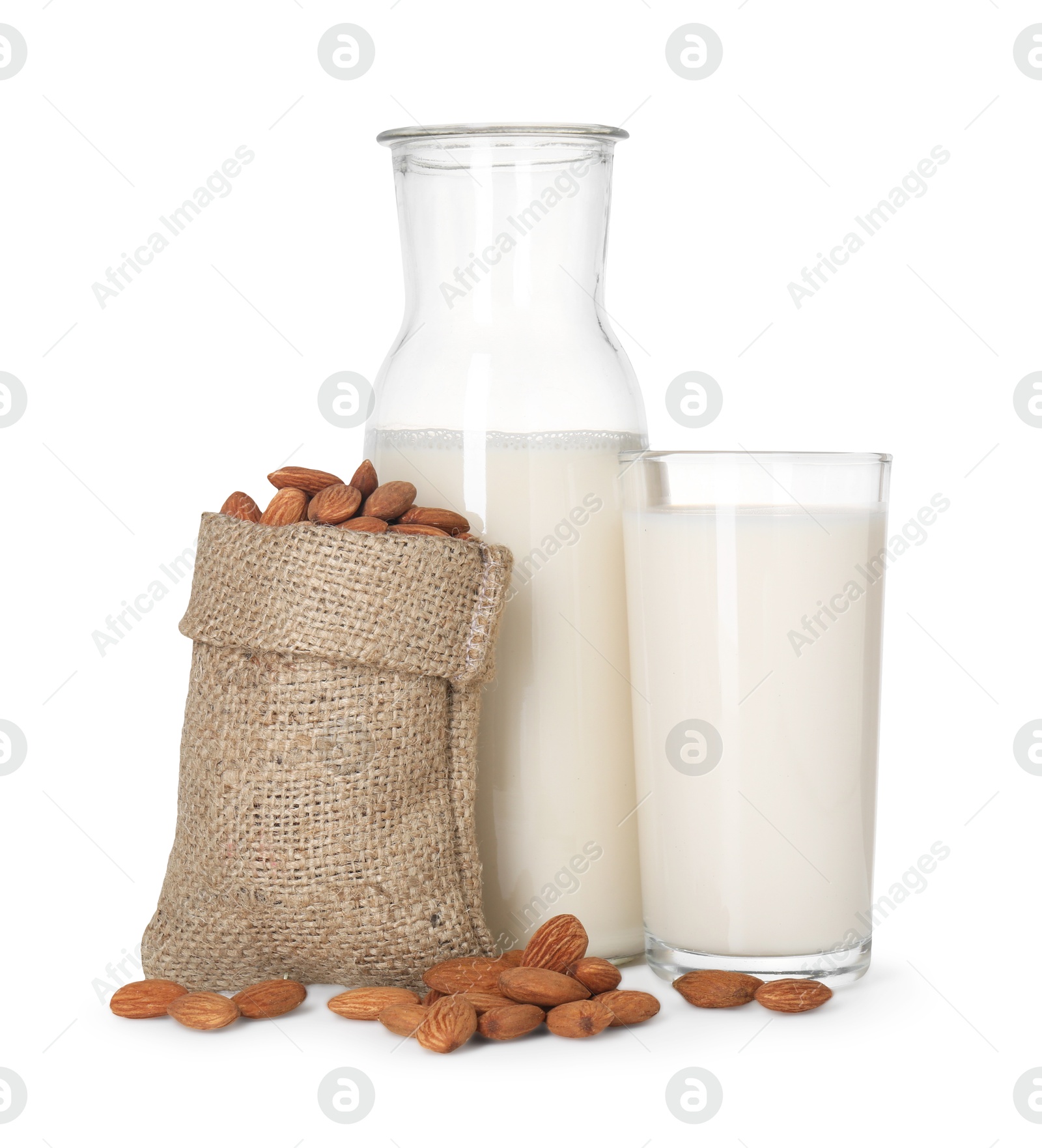 Photo of Glass of almond milk, jug and almonds isolated on white