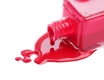 Bottle and spilled red nail polish isolated on white