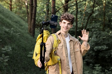 Photo of Travel blogger with smartphone and tripod streaming outdoors