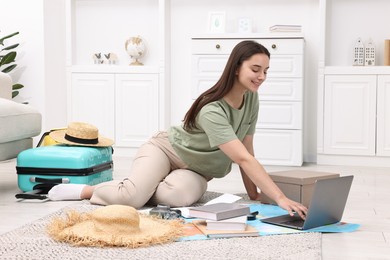 Photo of Travel blogger using laptop for planning trip at home