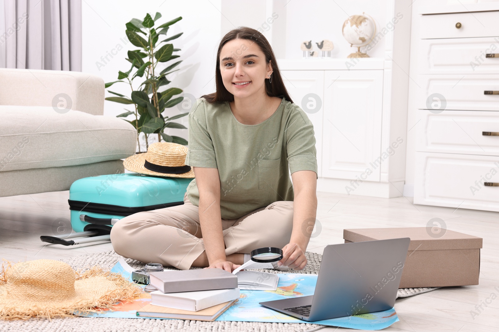 Photo of Travel blogger with magnifying glass and map planning trip at home