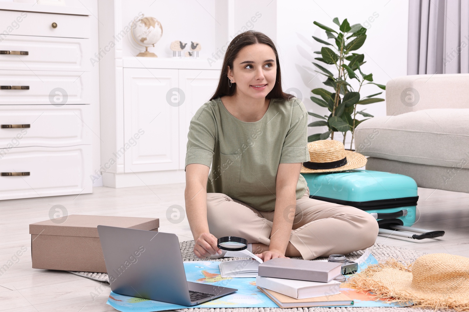 Photo of Travel blogger with magnifying glass and map planning trip at home