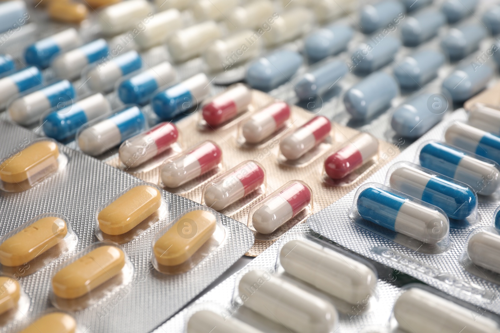 Photo of Antibiotic pills in blisters as background, closeup