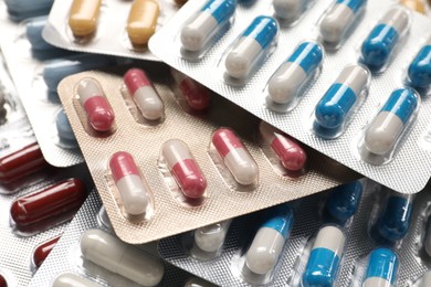 Photo of Antibiotic pills in blisters as background, closeup