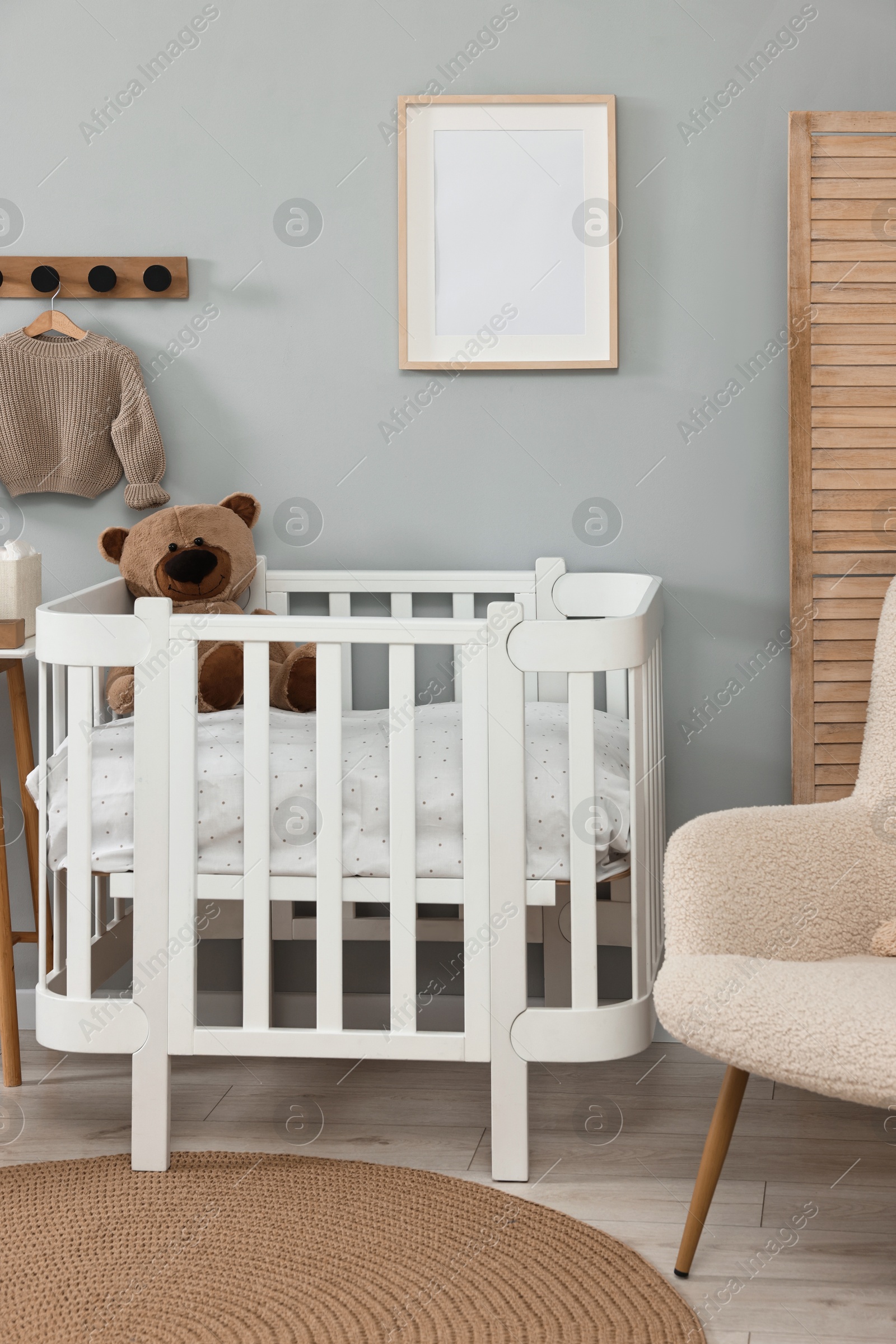 Photo of Newborn baby room interior with stylish furniture and comfortable crib