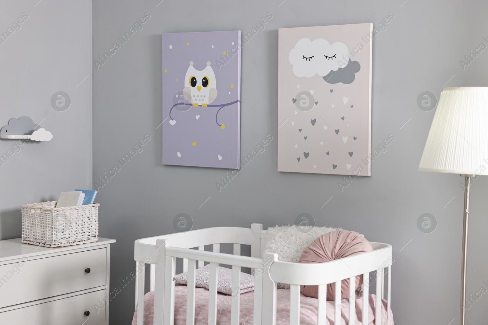 Photo of Newborn baby room interior with stylish furniture, comfortable crib and pictures of on wall