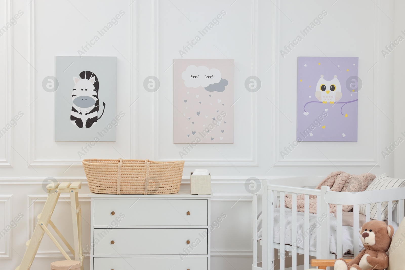 Photo of Newborn baby room interior with stylish furniture, comfortable crib and pictures of on wall