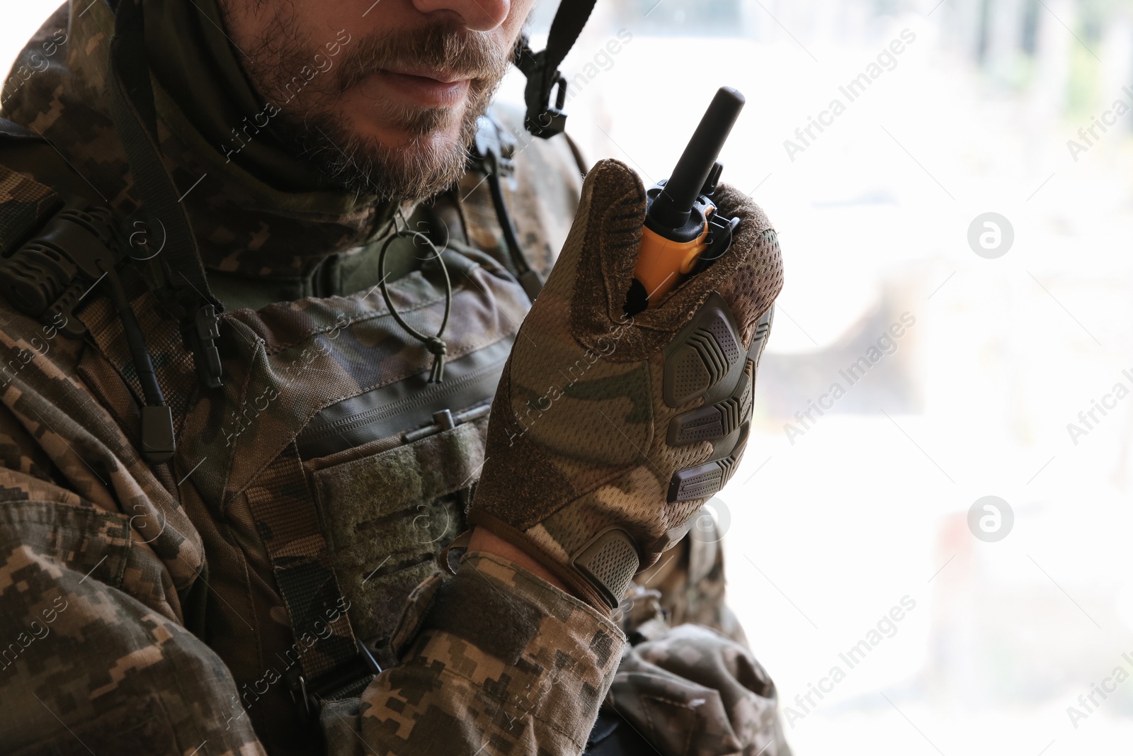 Photo of Military mission. Soldier in uniform with radio transmitter inside abandoned building