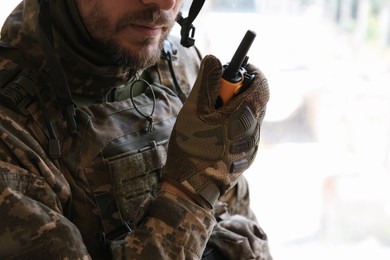 Military mission. Soldier in uniform with radio transmitter inside abandoned building