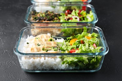 Photo of Healthy food. Different meals in glass containers on black table