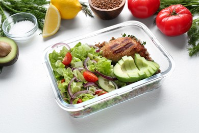 Healthy meal. Fresh salad, avocado and cutlet in glass container near other products on white background