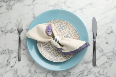 Photo of Stylish setting with cutlery and plates on white marble table, flat lay