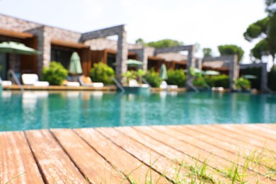 Outdoor swimming pool with wooden deck at resort, blurred view